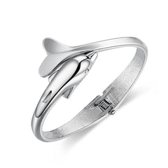 A silver-plated hinged bangle featuring an elegant dolphin design, showcasing a blend of style and marine inspiration.