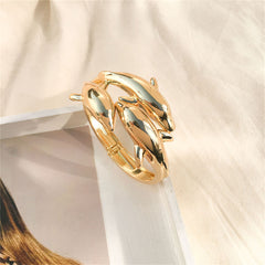 An 18K gold-plated bangle showcasing two dolphins in a stylish bypass design, perfect for any occasion.