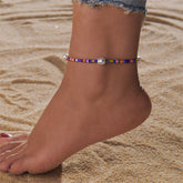 A vibrant stretch anklet featuring howlite and pearl beads, showcasing a colorful design with elegant pearls.