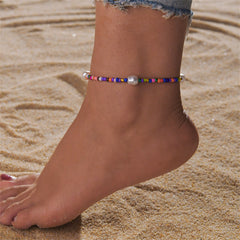 A vibrant stretch anklet featuring howlite and pearl beads, showcasing a colorful design with elegant pearls.