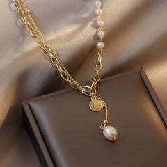 Chic lariat necklace made of gold, featuring a pearl and an 18K gold-plated coin charm, perfect for stylish accessorizing.