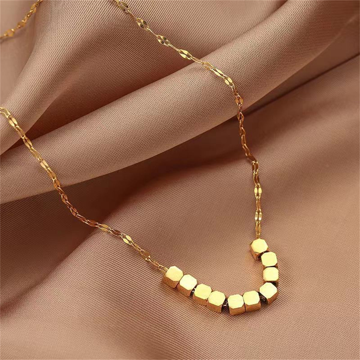 Elegant 18K gold-plated necklace featuring four stylish cubes, perfect for adding a touch of sophistication to any outfit.