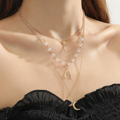 Three layered gold necklaces featuring a star, moon, and star design, elegantly crafted in 18K gold plating.