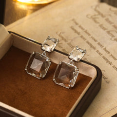 Two square cut crystal earrings with a silver-plated finish, offering a sophisticated touch to your jewelry collection.