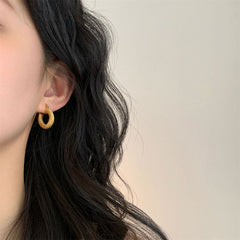 Stunning 18K gold plated braided hoop earrings with a unique twisted design, adding flair to your jewelry collection.