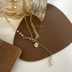 Stunning lariat necklace with a gold chain, adorned with a pearl and an 18K gold-plated coin charm for a chic look.