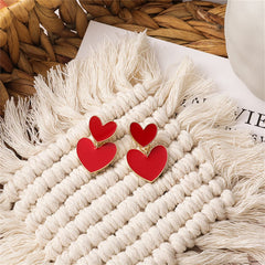 Charming red heart earrings with a gold-plated finish, showcasing a unique double-heart design.
