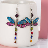 Colorful blue and pink crystal dragonfly earrings with silver-plated drop design, showcasing intricate wing details.