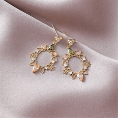 Stunning 18K gold-plated earrings shaped like hearts and flowers, embellished with green and white stones and sparkling crystals.