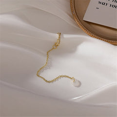 Chic gold-plated crisscross earring showcasing a pearl, complemented by dazzling cubic zirconia stones.