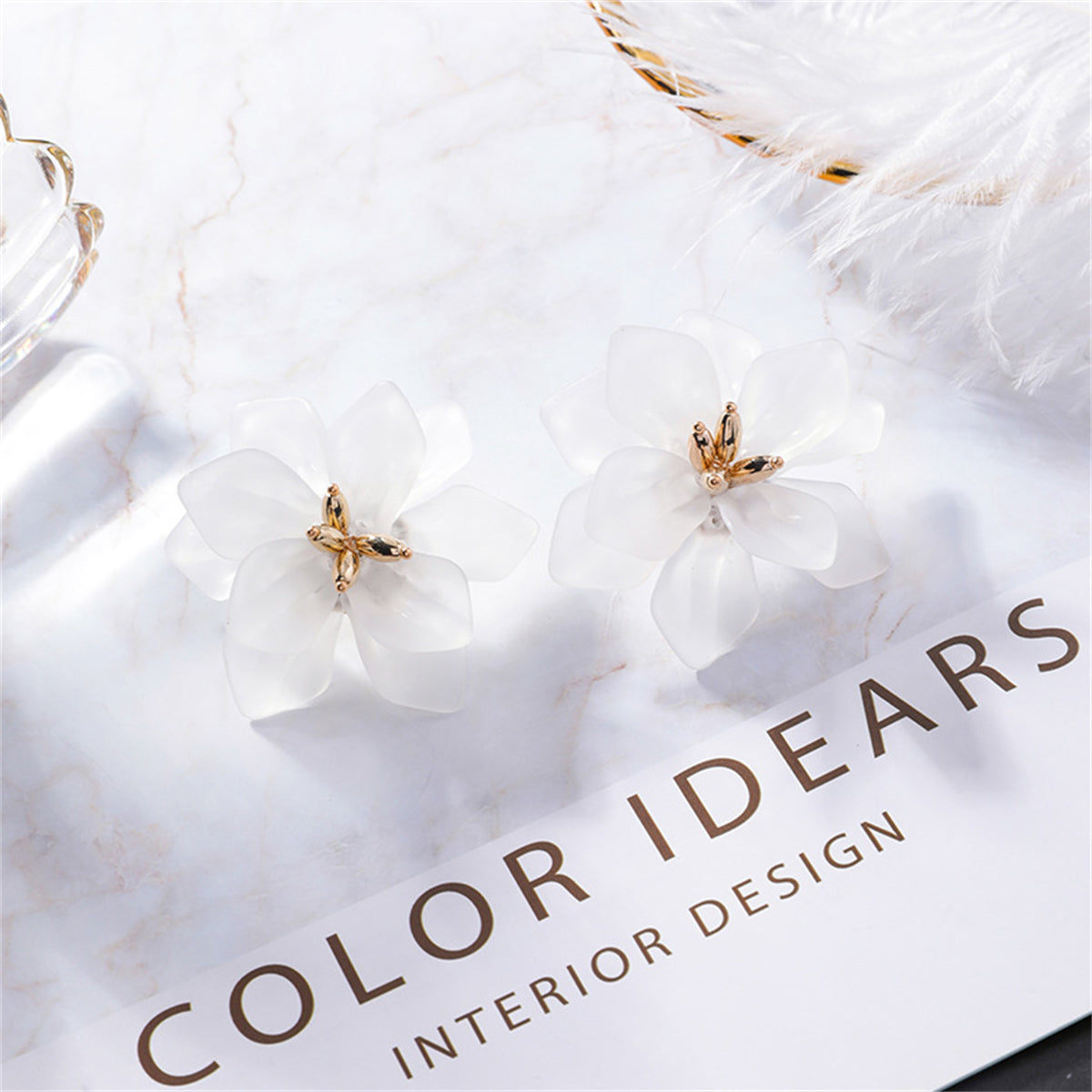 Elegant white flower stud earrings made of acrylic and 18K gold-plated for a touch of sophistication.