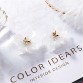 Elegant white flower stud earrings made of acrylic and 18K gold-plated for a touch of sophistication.