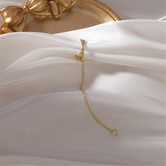 Beautiful gold-plated clip-on earring with a pearl and crisscross design, accented by cubic zirconia brilliance.