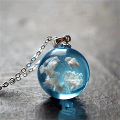 Blue topaz pendant on a silver chain, featuring a cloud design, adds elegance to any outfit.