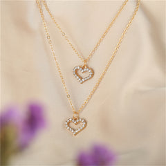 Stunning gold heart pendants embellished with diamonds, designed as a layered necklace in 18K gold plating.
