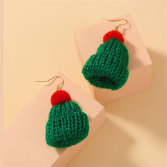 A pair of green and red knitted hats with pom poms, styled as festive Christmas accessories.