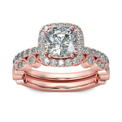 Elegant rose gold engagement ring with a cushion-cut diamond and a halo of sparkling cubic zirconia, complete with a band.