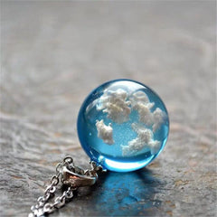 Silver-plated chain supports a beautiful blue topaz cloud pendant, combining elegance and whimsy in one piece.