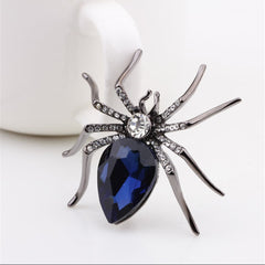 A dazzling blue spider brooch with diamond details, perfect for adding a whimsical touch to any outfit.