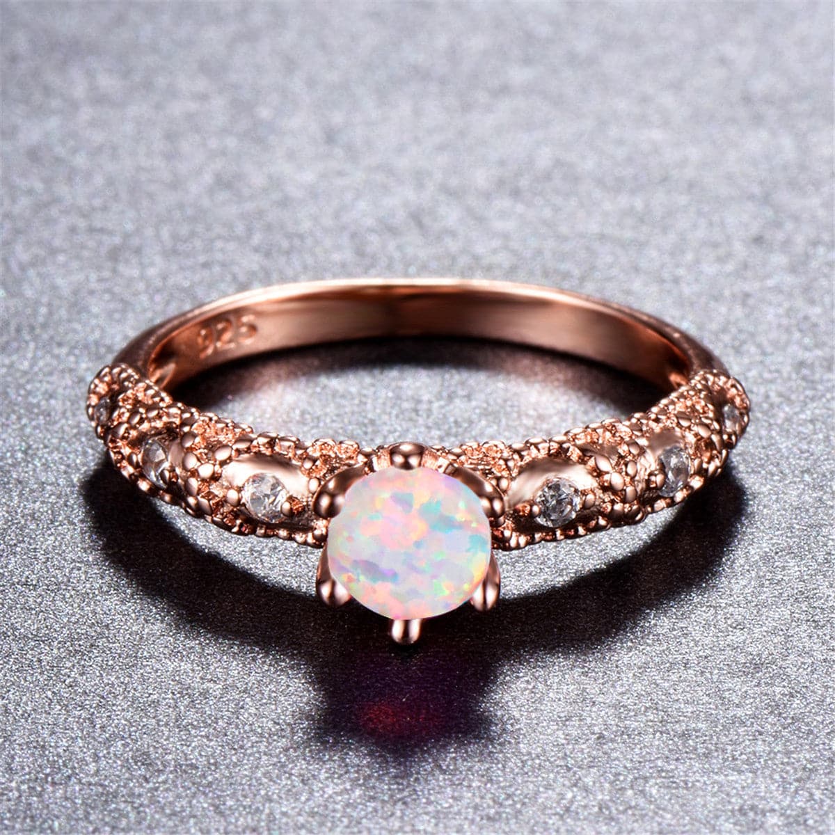 Elegant rose gold ring featuring a round opal stone, adorned with sparkling cubic zirconia accents.