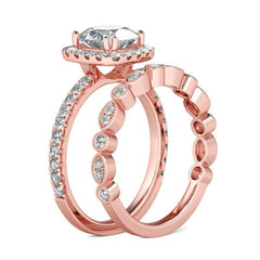 Stunning rose gold engagement ring showcasing a cushion-cut diamond encircled by a cubic zirconia halo and a coordinating band.