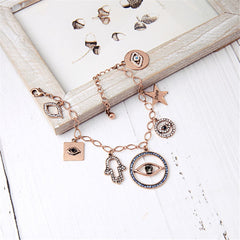 An elegant charm bracelet showcasing an evil eye, star, and lips, embellished with cubic zirconia and 18K gold.