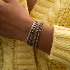 A set of four silver-plated Figaro chain bracelets, each with a stylish clasp, showcasing a chic accessory collection.