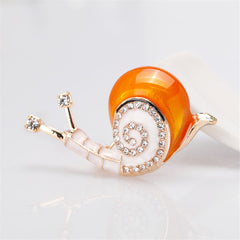 Elegant gold and white snail brooch adorned with sparkling cubic zirconia crystals, perfect for adding a touch of luxury.