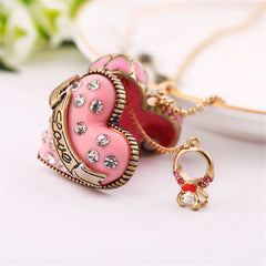 A pink heart locket with a diamond arrow, featuring cubic zirconia and 18K gold plating, symbolizing love and affection.