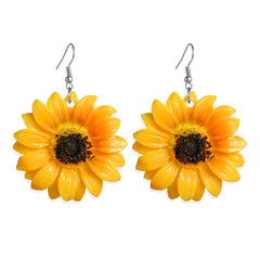 Bright yellow sunflower earrings with contrasting black centers, designed as elegant drop accessories.