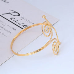 Beautiful 18K gold-plated arm cuff with a captivating spiral design, perfect for a sophisticated look.