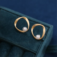 Gold-plated earrings with a pearl in the middle, featuring a chic open twist round design.