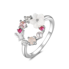 Elegant silver-plated ring with a white flower, adorned with pink stones and a butterfly, showcasing a floral open-circle design.