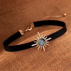 Stylish black choker with a radiant sunburst stone, featuring crystal and cubic zirconia, elegantly gold-plated.