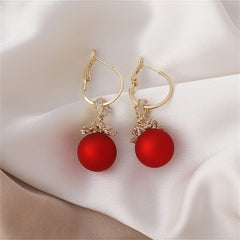 Vibrant red ball earrings embellished with diamonds, designed as 18k gold-plated flower huggies.
