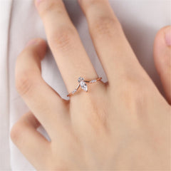 A rose gold ring featuring a stunning marquise-cut diamond, elegantly designed with cubic zirconia accents.