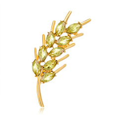 Exquisite gold-plated brooch adorned with vibrant green stones, showcasing a unique wheat design in 18K gold.
