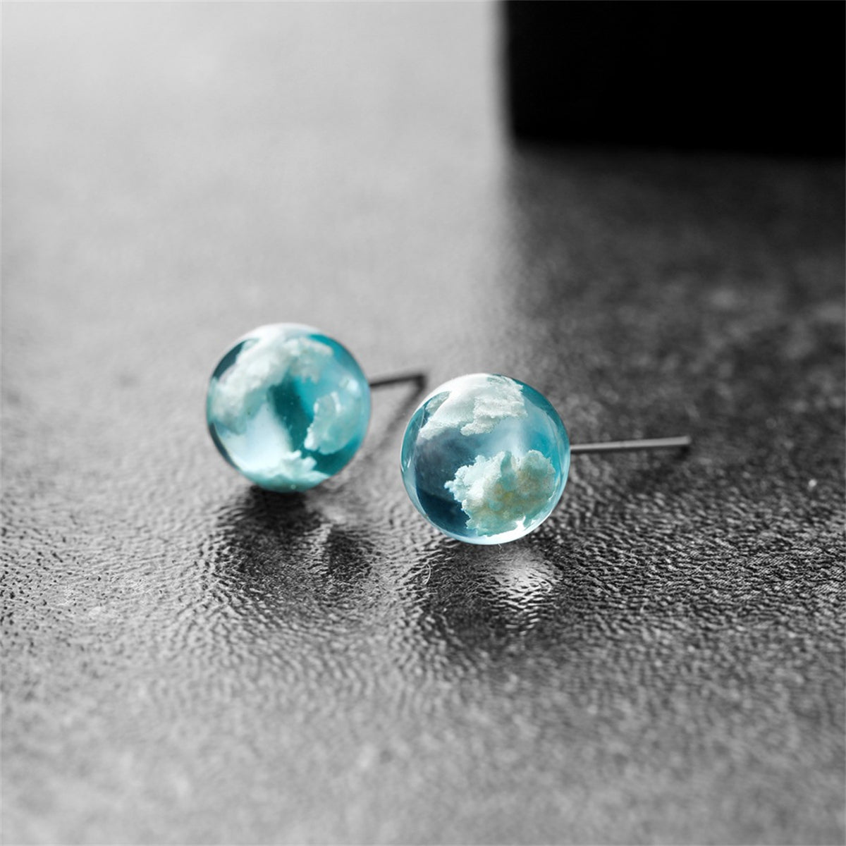 Blue and white marble stud earrings resembling clouds, adding a touch of elegance to any outfit.