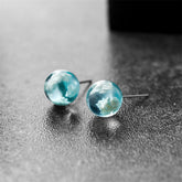 Blue and white marble stud earrings resembling clouds, adding a touch of elegance to any outfit.