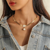 Elegant gold necklace featuring a pearl and heart charm on an 18K gold-plated snake chain with a clover pendant.