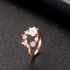 Stunning rose gold ring embellished with pink flowers and white stones, featuring a floral open-circle design in 18k plating.