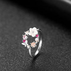 Silver-plated open-circle ring with a white flower, embellished with pink stones and a butterfly, perfect for a delicate look.