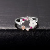 A silver-plated floral ring featuring a white flower design, pink cubic zirconia stones, and a delicate butterfly accent.