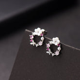 Pink flower earrings adorned with white stones, featuring opal and cubic zirconia in a butterfly and floral design.