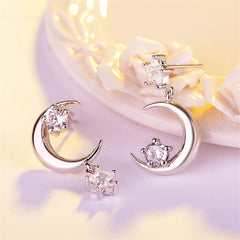 Two crescent diamond earrings with cubic zirconia, showcasing a silver-plated inverted moon and star drop style.
