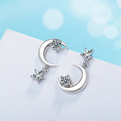 Two crescent-shaped diamond earrings featuring cubic zirconia and silver-plated moon and star drop design.