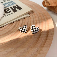Stylish black and white checkered heart stud earrings, featuring a chic enamel design for a trendy accessory look.