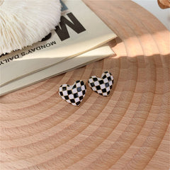 Eye-catching black and white checkered heart studs made of enamel, ideal for a bold yet playful fashion statement.