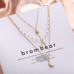 Three exquisite gold necklaces layered together, adorned with a star, moon, and star, crafted in 18K gold plating.