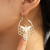Elegant 18K gold-plated bee and honeycomb drop earrings, perfect for adding a touch of nature-inspired charm to any outfit.